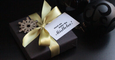 gift wrapped in black with mistletoe gift tag