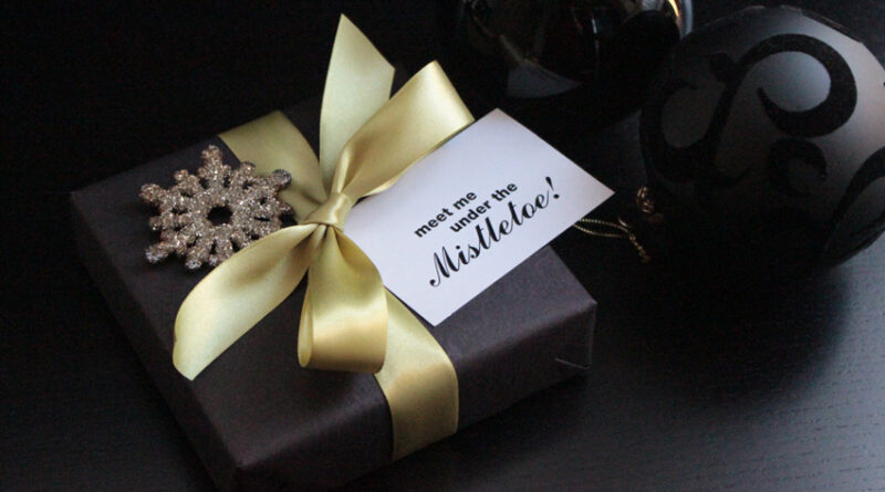 gift wrapped in black with mistletoe gift tag